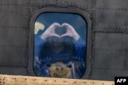 Newly released Israeli hostage Liri Albag gestures a heart shape with her hands from the window of a military helicopter as it prepares to land at the Beilinson Hospital in Petah Tikva on Jan. 25, 2025.