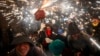 People dance as revelers hold fireworks as they take part in a "Correfoc", or run with fire, party in Barcelona, Spain, Sept. 15, 2024. 