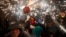 People dance as revelers hold fireworks as they take part in a "Correfoc", or run with fire, party in Barcelona, Spain, Sept. 15, 2024. 