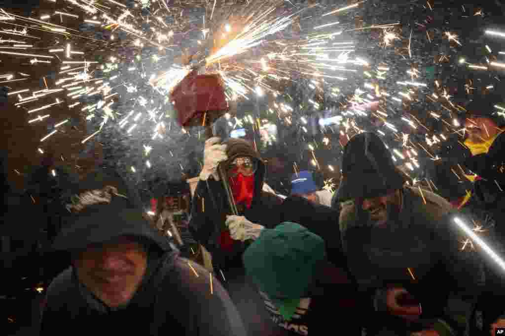 Para pengunjung bersuka ria mengikuti pesta &quot;Correfoc,&quot; atau lari bersama sambil membawa api, di kota Barcelona, ​​Spanyol. (AP)&nbsp;