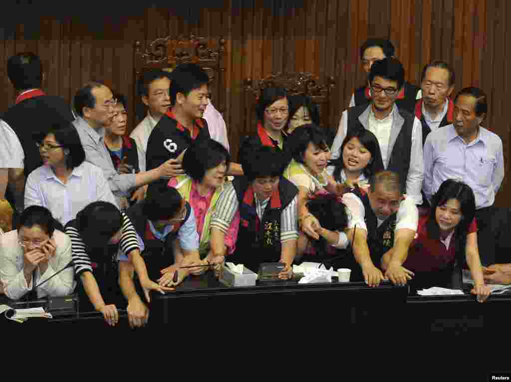 Para legislator oposisi dari Partai Demokrat Progresif (dalam rompi hijau, tidak tampak) bentrok dengan legislator dari partai yang berkuasa, Partai Nasionalis (dalam rompi hitam) di Taipei, Taiwan.