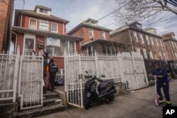 FILE—African migrants confer outside a residence that serves as Bronx's Masjid Ansaru-Deen mosque, March 15, 2024, in New York.