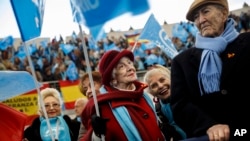 Supporters of the Popular Party wait for the arrival of the leader Mariano Rajoy during an electoral campaign meeting, Dec. 13, 2015.