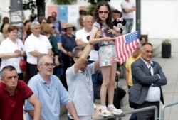 FILE - A girl holding a U.S. flag attends the 20th anniversary of the deployment of NATO troops in Kosovo, in Pristina, Kosovo June 12, 2019.
