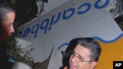 Miguel Acebo, first secretary of the Communist Party in the Santi Spiritus province, speaks with unidentified people next to the wreckage of a Cuban airliner that crashed near the village of Guasimal, Santi Spiritus, in Cuba, 04 Nov 2010