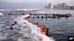 FILE - SEAL candidates participating in "surf immersion" during Basic Underwater Demolition/SEAL (BUD/S) training at the Naval Special Warfare (NSW) Center in Coronado, California. (May 4, 2020 photo provided by the U.S. Navy)
