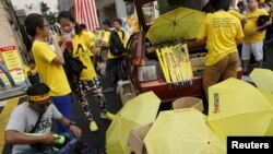 FILE - People sell umbrellas to supporters of pro-democracy group "Bersih" (Clean) near Dataran Merdeka in Malaysia's capital city of Kuala Lumpur, Aug. 30, 2015.