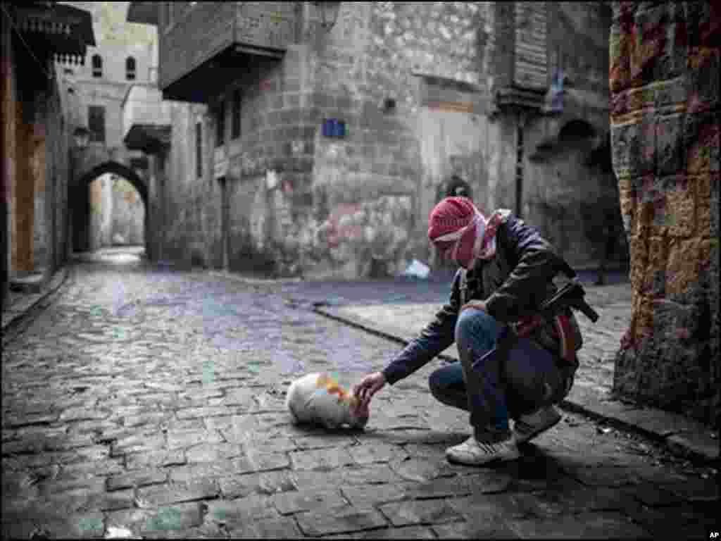 شام میں کشیدہ حالات کے دوران ایک شخص اسلحہ تھامے بلی کو روٹی کھلارہا ہے