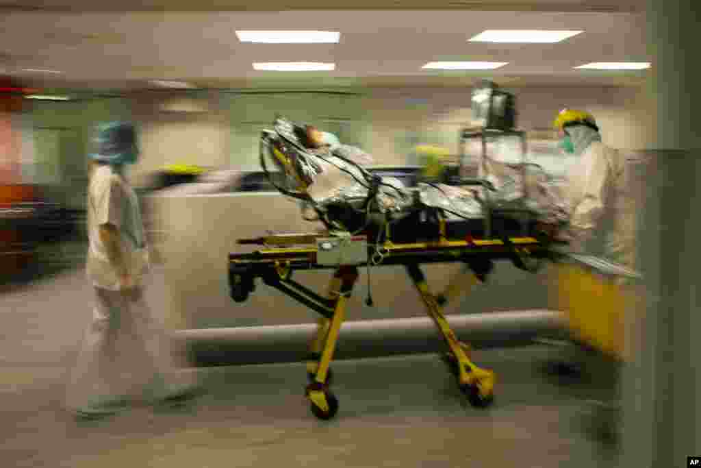 Medical staff transfer a COVID-19 patient, due to the lack of room, from the CHR Citadelle hospital in Liege, Belgium, Wednesday, Oct. 21, 2020. Authorities in Belgium fear another deadly wave of coronavirus cases could soon hit care homes for the elderly