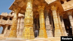FILE - A security guard stands amid the gold-plated pillars of the Hindu god Shiva temple at Somnath in the western Indian state of Gujarat, Feb. 1, 2014. 