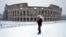 A man stands in front of the ancient Colosseum blanketed by the snow in Rome, Feb. 26, 2018. 