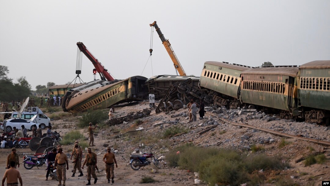 Gerbong-gerbong kereta api diangkat dengan derek di lokasi kecelakaan menyusul tergelincirnya kereta api penumpang di kota Nawabshah, Pakistan Minggu 6 Agustus 2023.