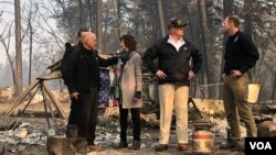 Presiden AS Donald Trump (bertopi) mengunjungi kota Paradise, California yang paling parah terkena dampak kebakaran hutan (17/11). 