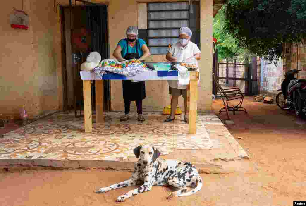 Muchas personas han emprendido negocios para poder satisfacer sus necesidades b&#225;sicas. Estas paraguayas preparan Milanesas para vender, en Nemby, Paraguay.