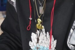 A protester wears a necklace depicting Muqtada al-Sadr, a prominent Shi’ite cleric and leader who has called on his supporters to join the rallies to demand U.S. forces leave Iraq, pictured on Jan. 21, 2020 in Baghdad. (Heather Murdock/VOA)