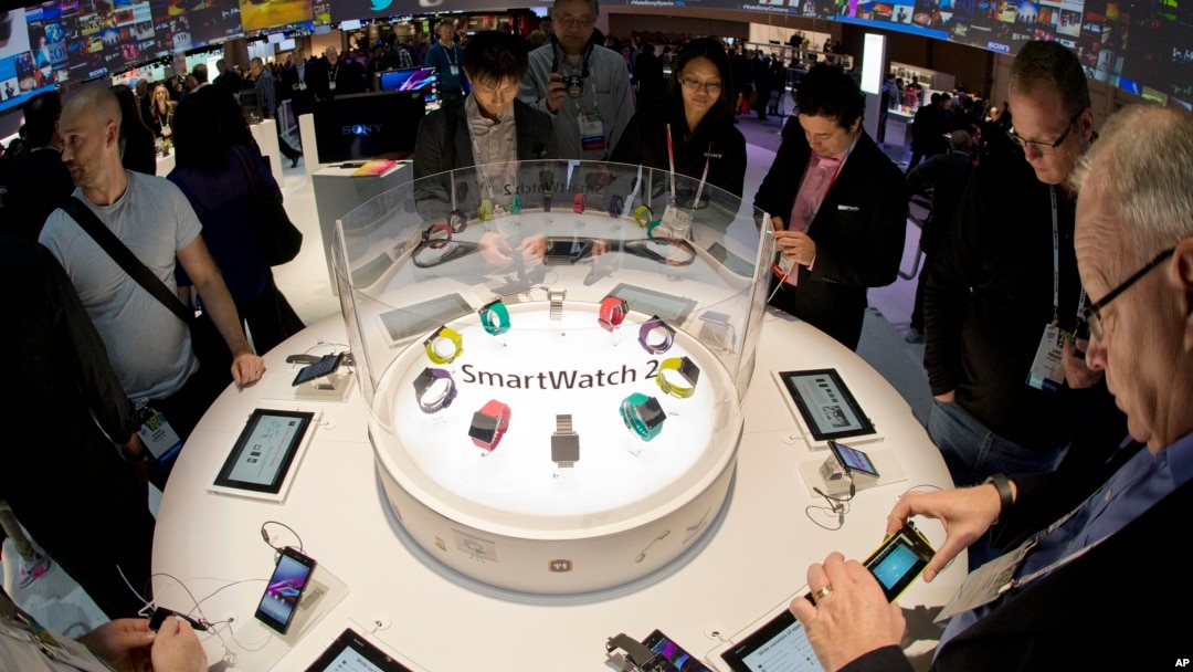 FILE - Trade show attendees examine the Sony Smart Watch 2 on display at the International Consumer Electronics Show, Jan. 8, 2014, in Las Vegas. High-tech tools can be used to help students cheat on exams, experts say.