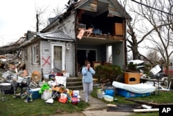 Brittany Oakley habla con familiares fuera de lo que queda de su casa en Lakeview, Ohio, el viernes 15 de marzo de 2024. Tormentas severas con presuntos tornados han dañado hogares y negocios en el centro de Estados Unidos. (Foto AP/Timothy D. Easley)