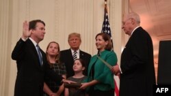 Brett Kavanaugh (L) is sworn-in as Associate Justice of the US Supreme Court by Associate Justice Anthony Kennedy (R) before wife Ashley Estes Kavanaugh (2nd-R), daughters Margaret (2nd-L) and Elizabeth (C), and US President Donald Trump at the White Hous