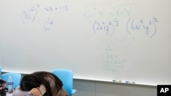 FILE - A student takes a break next to a whiteboard during a summer math boot camp on Aug. 1, 2023, at George Mason University in Fairfax. Virginia. (AP Photo/Kevin Wolf)