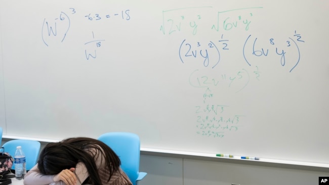 FILE - A student takes a break next to a whiteboard during a summer math boot camp on Aug. 1, 2023, at George Mason University in Fairfax. Virginia. (AP Photo/Kevin Wolf)