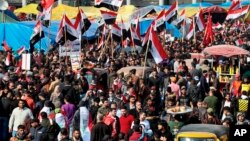 Ratusan orang berkumpul di Lapangan Tahrir sambil membawa bendera nasional dan meneriakkan slogan-slogan, Baghdad, Irak, 5 Desember 2019.