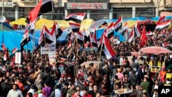 Ratusan warga berunjuk rasa di Lapangan Tahrir membawa bendera nasional sambil meneriakkan yel-yel di Baghdad, Irak, 5 Desember 2019. (Foto: dok).