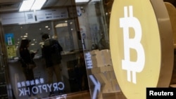 Pelanggan berdiri di toko pertukaran mata uang kripto setelah Bitcoin melonjak di atas $100.000, di Hong Kong, China, 5 Desember 2024. (Tyrone Siu/REUTERS)