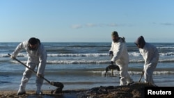 Sejumlah relawan membersihkan pantai dari pasir yang telah terkontaminasi tumpahan minyak dari Laut Hitam, di wilayah Vityazevo, Rusia, pada 20 Desember 2024. (Foto: Reuters/Sergey Pivovarov)