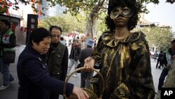 Passerby pick up condoms during an AIDS awareness event held by local community on the World AIDS Dayin Shanghai, China. December 1, 2011.