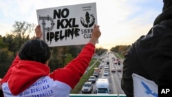 Opponents of the Keystone XL pipeline demonstrate on the Dodge Street pedestrian bridge during rush hour in Omaha, Neb., Nov. 1, 2017. The Nebraska Public Service Commission has until Nov. 23 to decide whether to approve or reject a proposed state route f