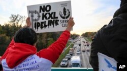 Opponents of the Keystone XL pipeline demonstrate on the Dodge Street pedestrian bridge during rush hour in Omaha, Neb., Nov. 1, 2017. The Nebraska Public Service Commission has until Nov. 23 to decide whether to approve or reject a proposed state route for the Keystone XL pipeline.