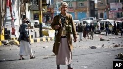 Houthi Shiite Yemeni gather while guarding a street leading to the presidential palace in Sanaa, Yemen, Jan. 20, 2015.