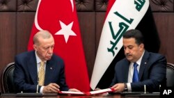 Presiden Turki Recep Tayyip Erdogan, kiri, dan PM Irak Mohammed Shia al-Sudani saling menandatangani perjanjian selama pertemuan mereka di Baghdad, Irak pada 22 April 2024 (foto: dok). 