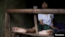 FILE - A man suffering from mental illness sits chained on a bed in his room inside his family home in Curug Sulanjana village in Serang, Banten province, Indonesia, March 23, 2016. 