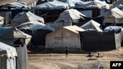 FILE - Children play among tents at the Kurdish-run al-Hol camp, in the northeastern Syrian Hasakeh governorate, Feb. 17, 2021. Many of the families released from the camp have struggled to make a new life in their hometown of Sarrin, Syria. 