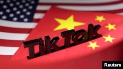 FILE - The TikTok logo is placed on the U.S. and Chinese flags in this illustration.