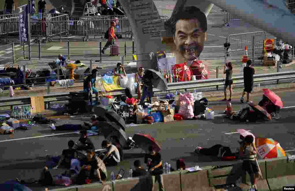 A defaced cut-out of Hong Kong Chief Executive Leung Chun-ying is seen as protesters block a street outside the government headquarters in Hong Kong, September 30, 2014.