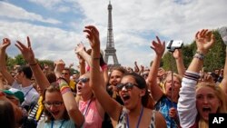 Anak-anak menikmati konser di acara Vacation for Everyone di Menara Eiffel di Paris, Perancis (19/8).