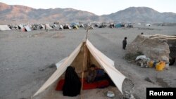 FILE - Internally displaced Afghan family sits inside a tent at a refugee camp in Herat province, Afghanistan, Oct. 14, 2018. 