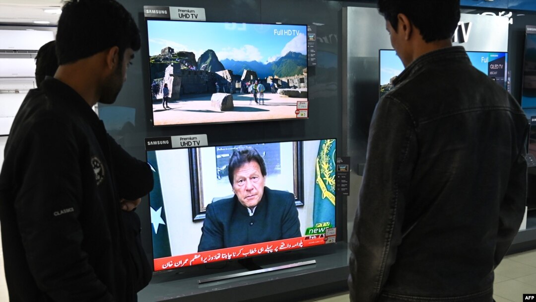 FILE - People watch Pakistani Prime Minister Imran Khan address the nation on TV following the Feb. 14 suicide bombing in Indian-administered Kashmir, in Islamabad, Feb. 19, 2019.