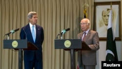 Menlu AS John Kerry menyimak saat Sartaj Aziz, Penasehat Keamanan Nasional dan Urusan Luar Negeri Pakistan, memberikan sambutan dalam konferensi pers bersama di Islamabad (1/8).