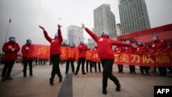 El personal médico de un hospital temporal en Wuhan, China, celebra la salida del último paciente de coronavirus el 9 de marzo de 2020.