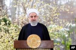 In this photo released by the official website of the office of the Iranian Presidency, President Hassan Rouhani delivers a message in Tehran, Iran, March 20, 2020.