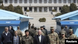 U.S. Secretary of State Rex Tillerson stands with U.S. Gen. Vincent K. Brooks (third from right) and Gen. Leem Ho-young (third from left), as North Korean soldiers look at the south side in the border village of Panmunjom, which has separated the two Koreas since the Korean War, March 17, 2017.