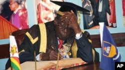 In this Friday Oct. 2, 2015 photo, Zimbabwean President Robert Mugabe writes his comments in a visitors' book at the University of Zimbabwe in Harare.