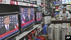 A Palestinian watches the speech of US President Barack Obama on television at a store in Gaza City, May 19, 2011