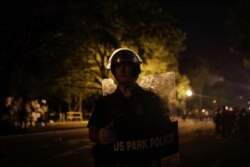 A. U.S. Park Police officer stands as police close the area around Lafayette Park near the White House after protesters tried to topple a statue of Andrew Jackson in the park in Washington, June 22, 2020.