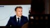 A man watches France's President Emmanuel Macron on a television screen in Paris during a live interview broadcasted on the French TV channel TF1's evening news and French public television news channel France 2 on September 24, 2023. (Photo by Geoffroy V