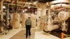 FILE - A worker walks past equipment in the turbine building at the Oyster Creek nuclear plant in Lacey Township, N.J., Feb. 25, 2010.