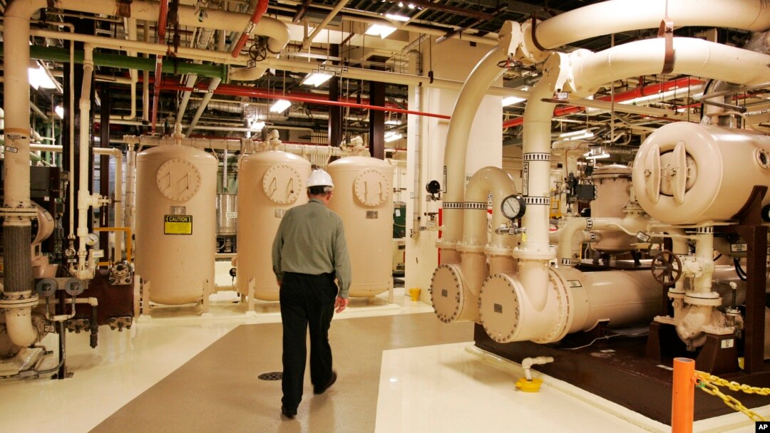 FILE - A worker walks past equipment in the turbine building at the Oyster Creek nuclear plant in Lacey Township, N.J., Feb. 25, 2010.